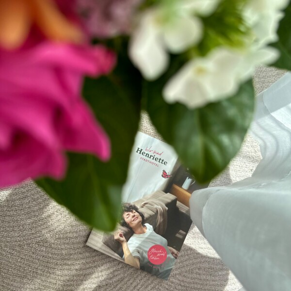 Blumen und Hotelbroschüre des Stadthotel Henriette Wien.
