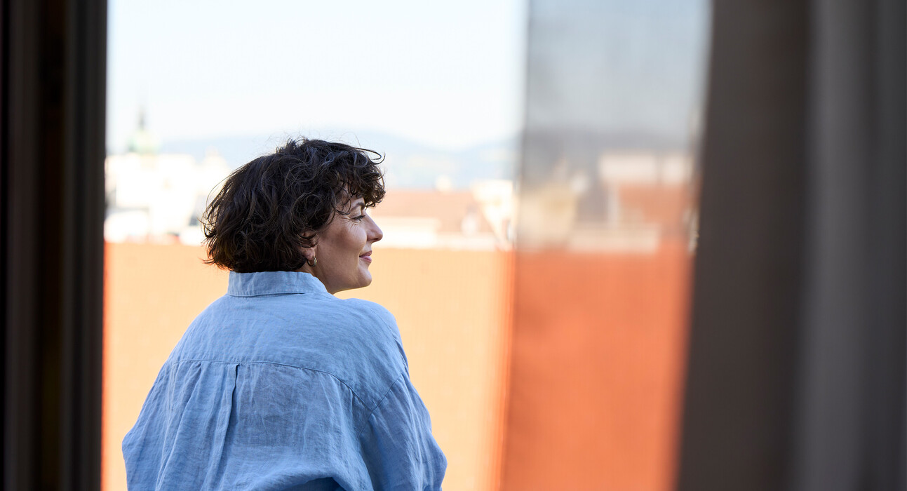 Dame stehend auf einem Balkon im zentralen Hotel Henriette in Wien