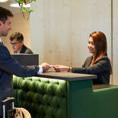 Geschäftsreisender beim Check-in im Henriette Stadthotel nahe der Messe Wien.